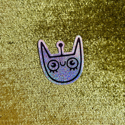 Holographic cat-shaped sticker on a textured gold background