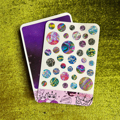 Sticker sheet with colorful planet designs on a green textured surface