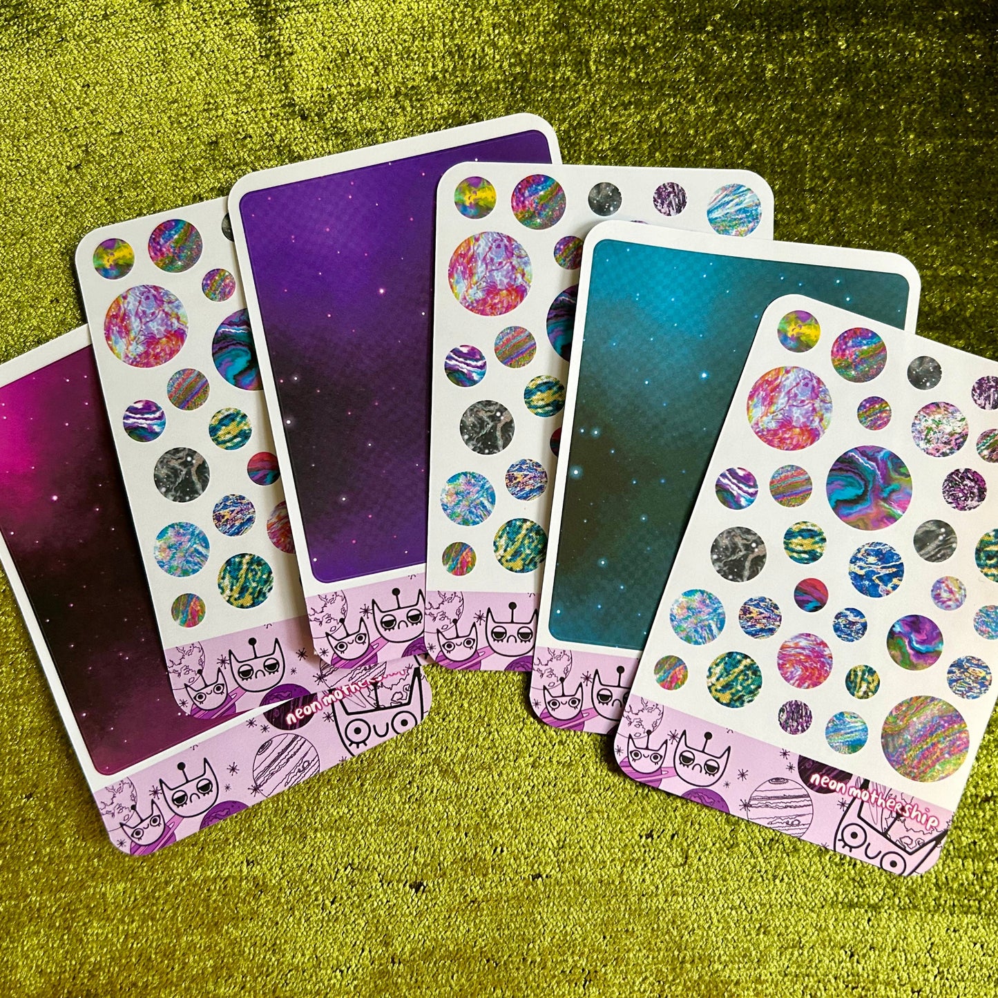 Set of colorful planet stickers on a textured green surface