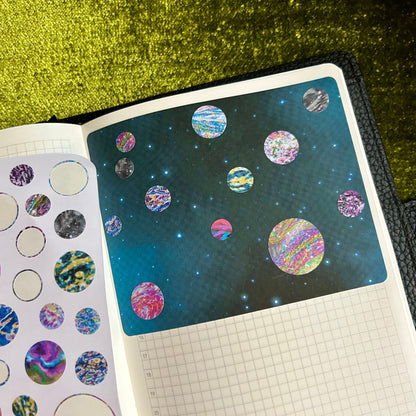 Sticker album with space-themed stickers on a green glittery background
