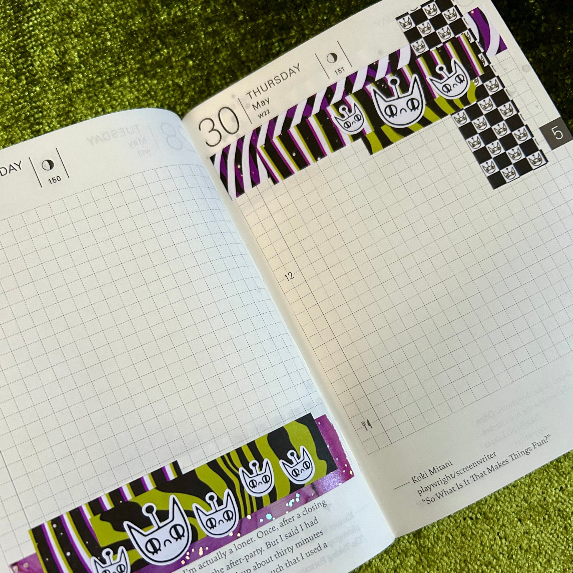 Open planner with decorative stickers on a green textured surface
