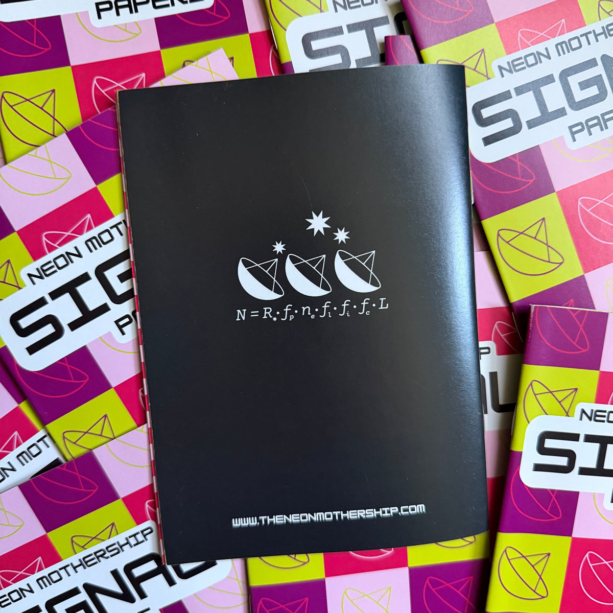 A black notebook with white stars and star graphic lies on top of several bright pink, purple, and yellow patterned 'Neon Mothership Signals Papers' sheets.