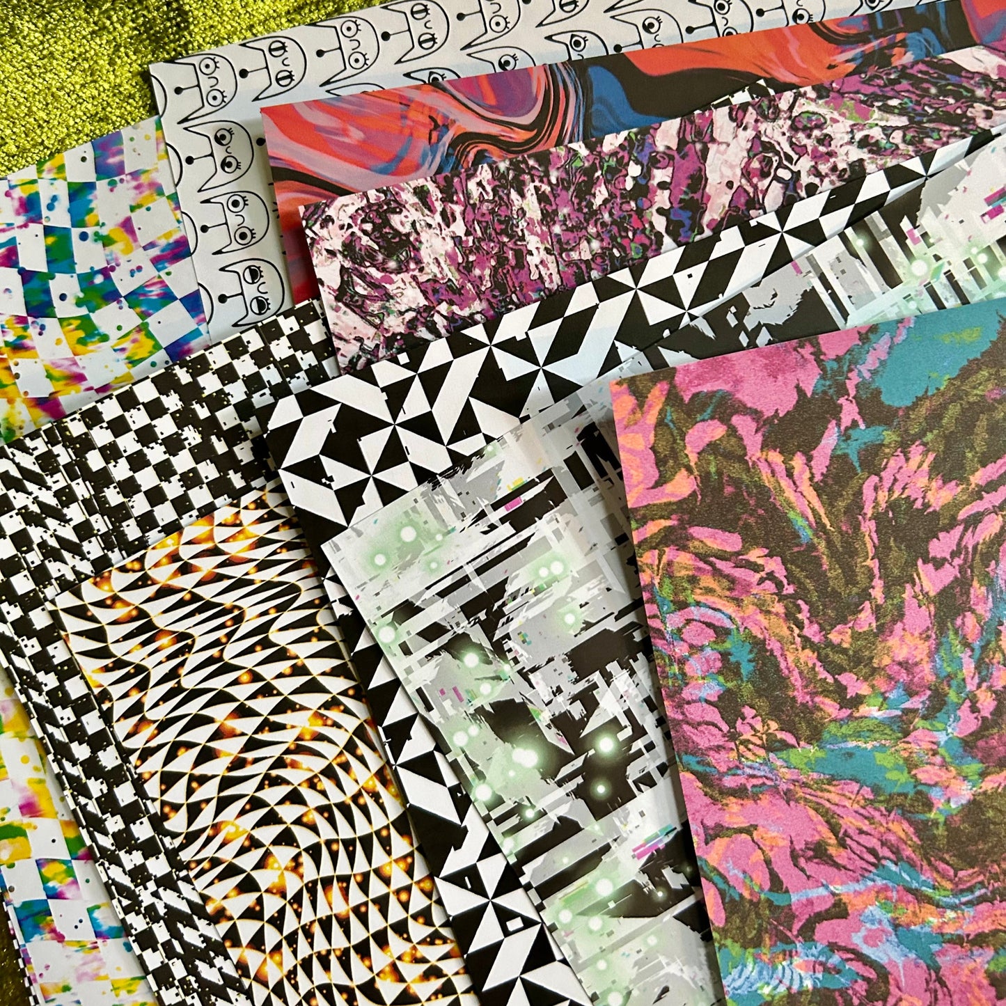 Collection of colorful patterned paper sheets on a textured surface