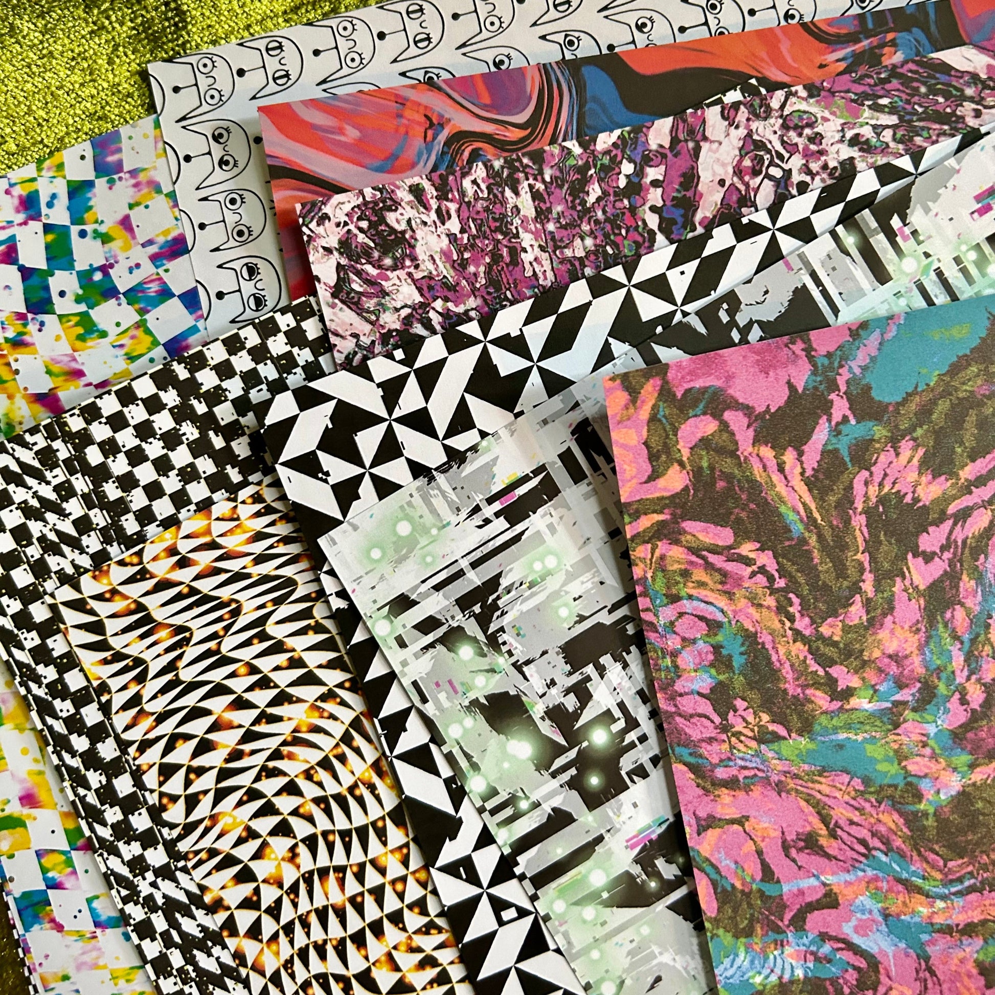 Collection of colorful patterned paper sheets on a textured surface