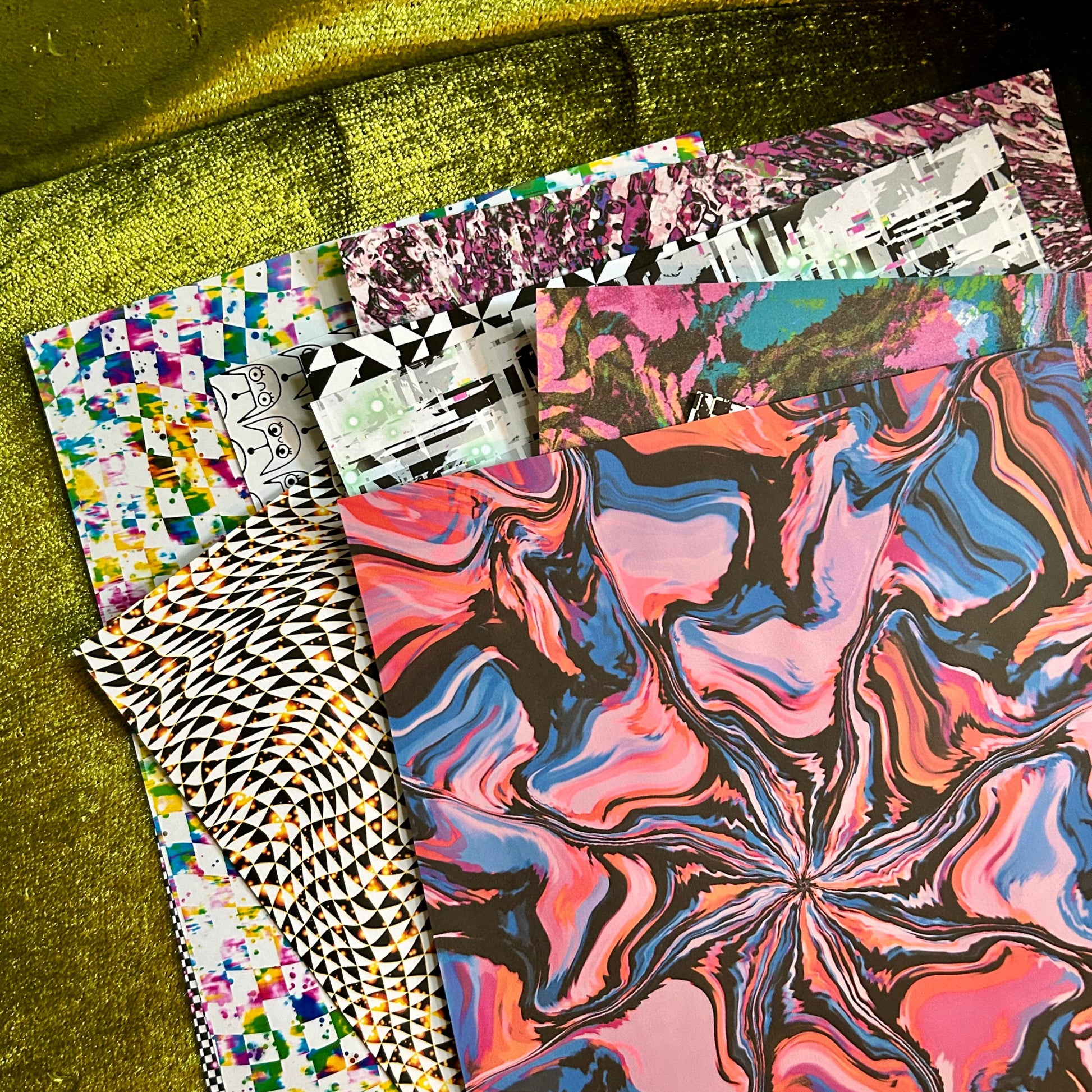 Colorful patterned paper stacks on a green textured surface