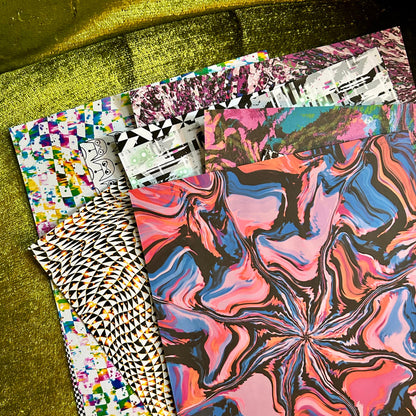 Colorful patterned paper stacks on a green textured surface