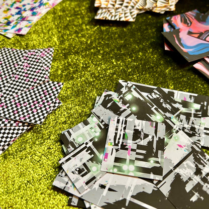 Stack of black and white patterned sticker scraps on a green textured surface