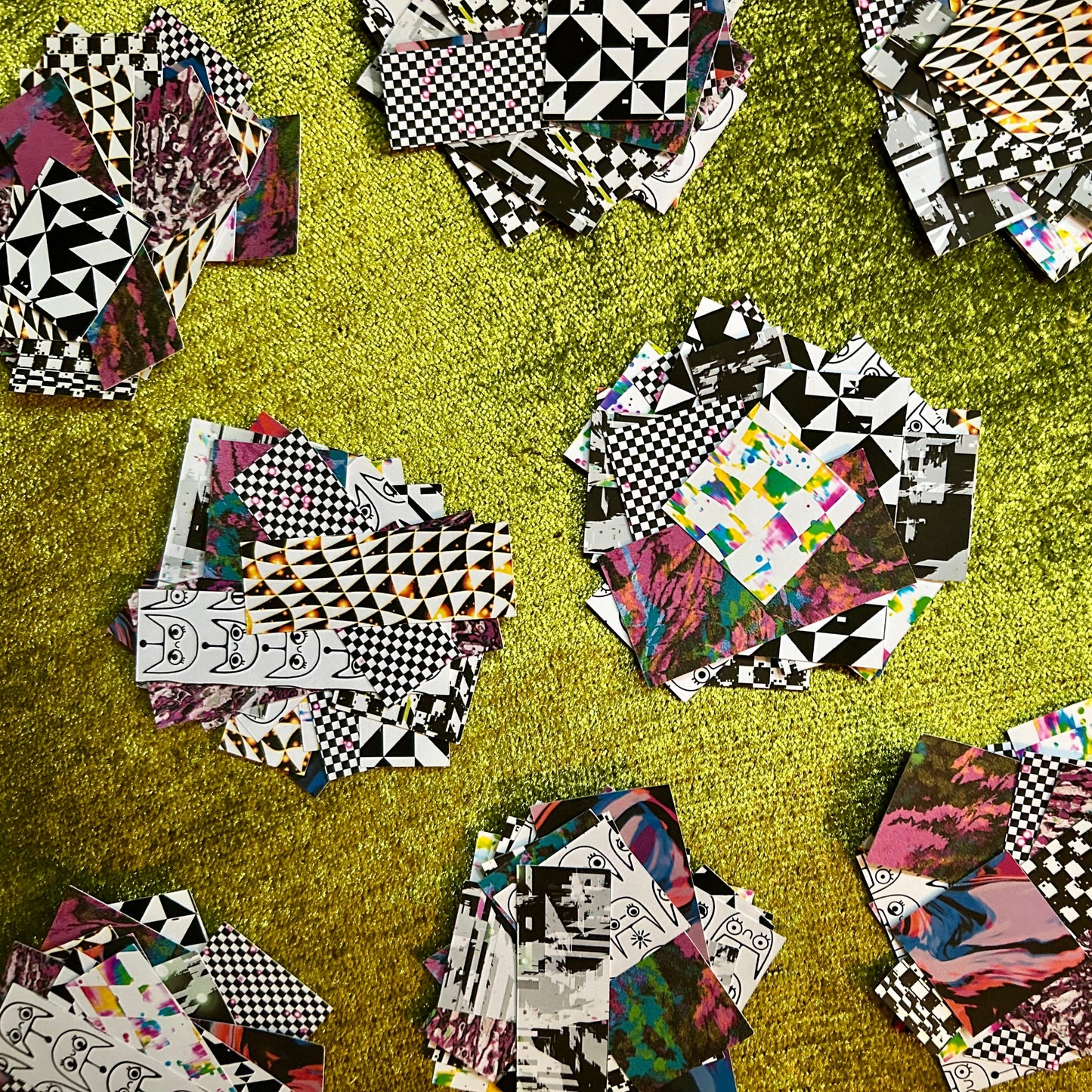 Collage of various patterned sticker scrap squares on a green surface