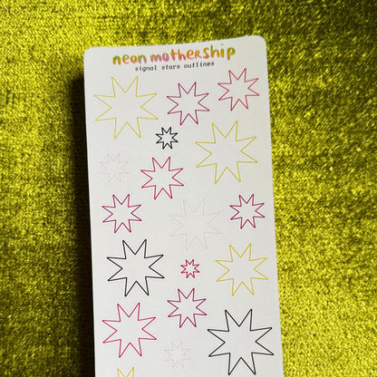 A sticker sheet from the brand 'neon mothership' featuring various neon-colored star and sparkle outlines on a white backing card, set against a textured yellow background.