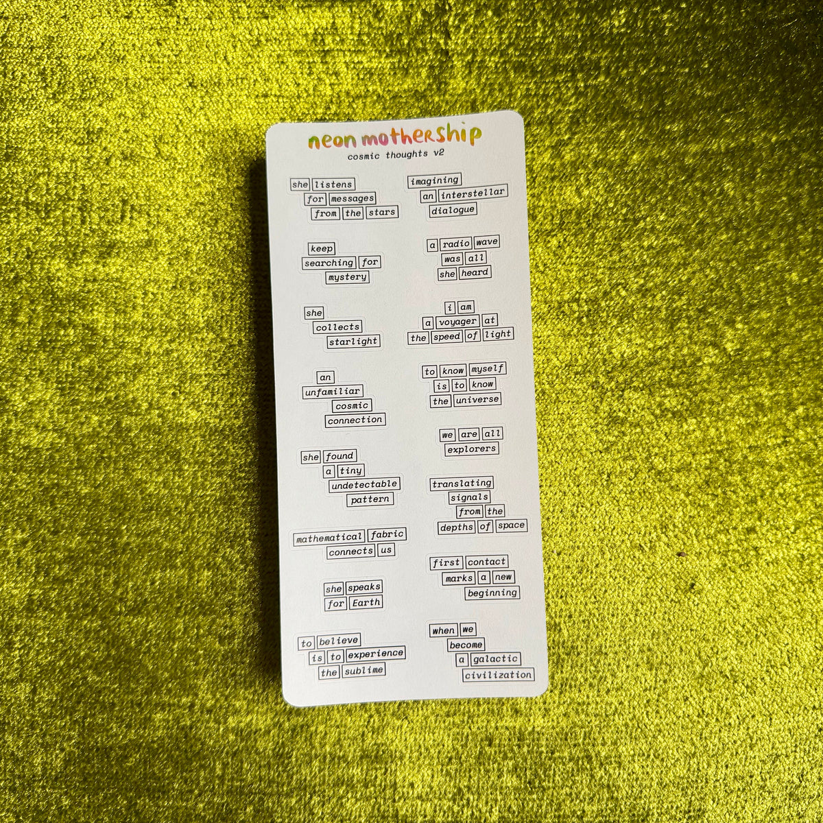 a sticker sheet with cosmic phrases on a green textured background