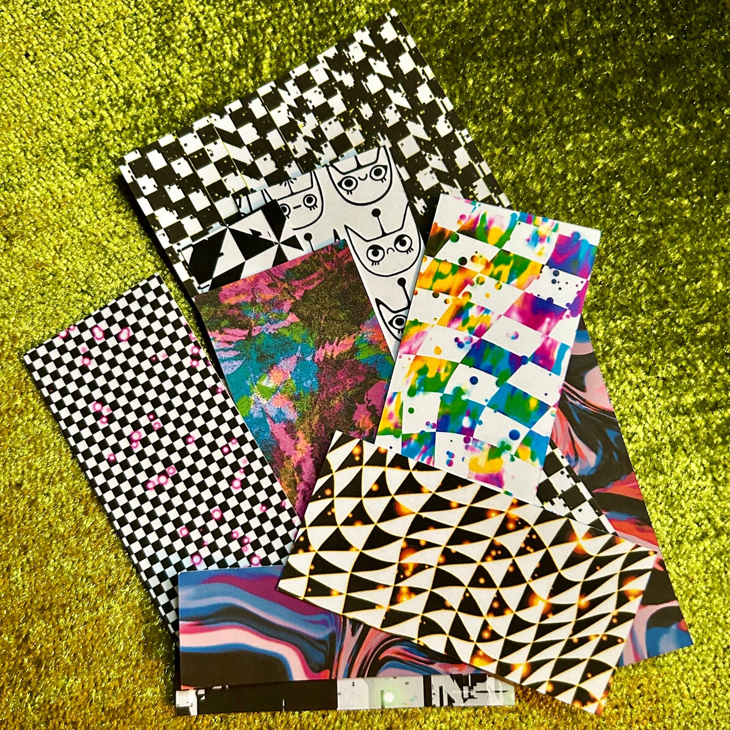 Collection of sticker scraps with various designs on a green textured surface