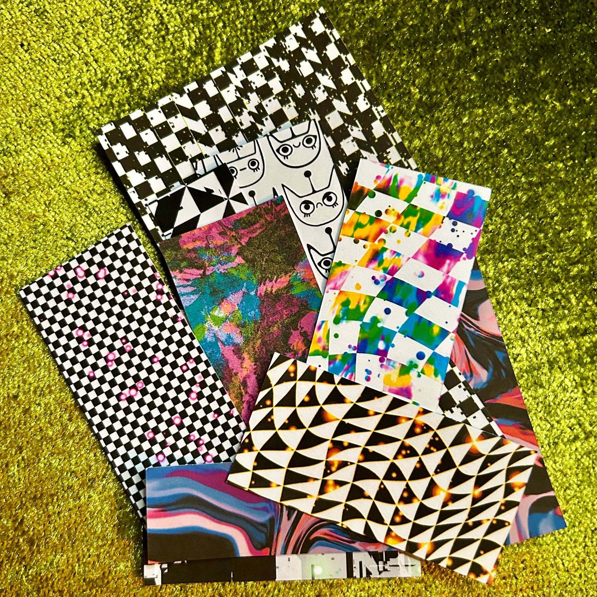 Collection of sticker scraps with various designs on a green textured surface