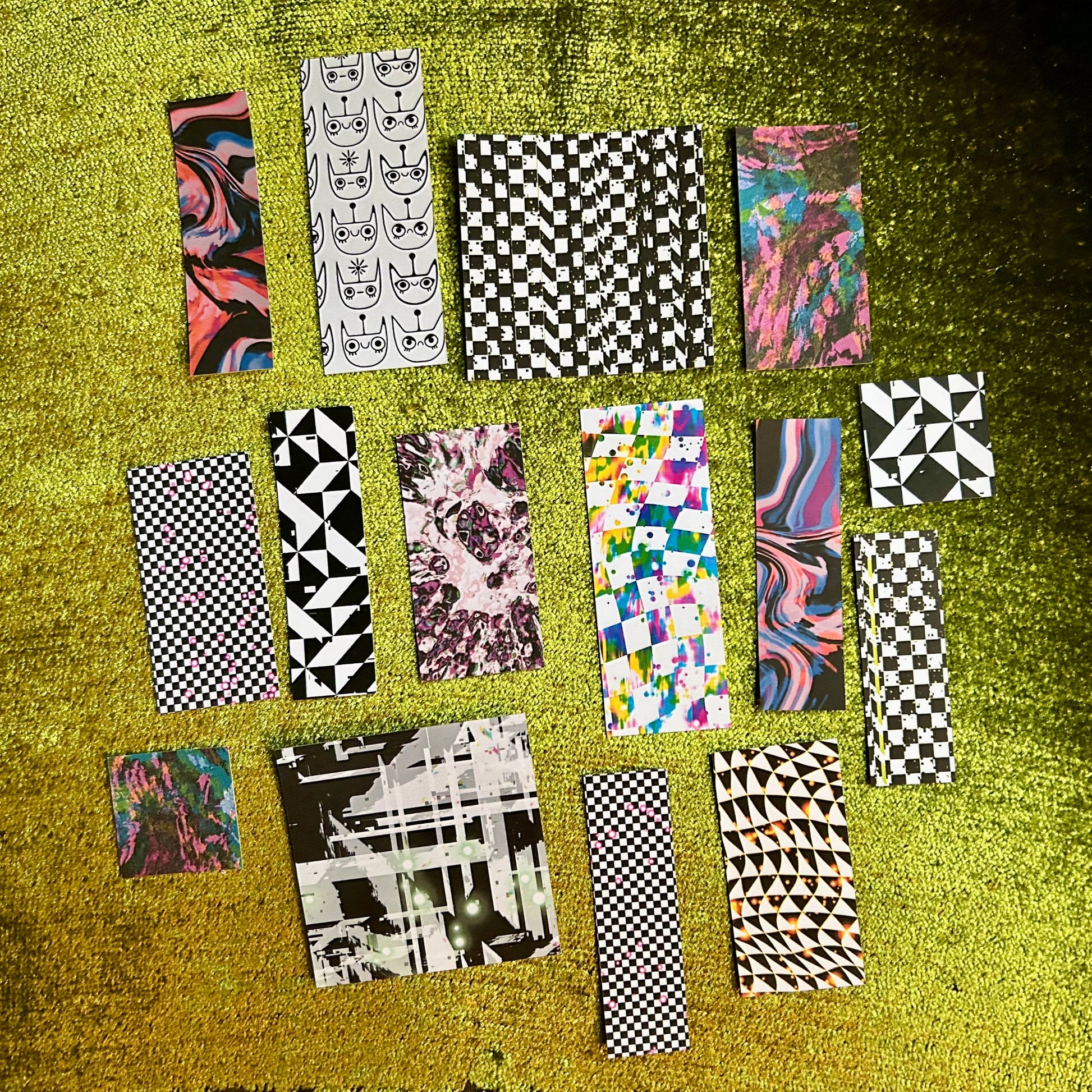 Collection of patterned sticker sheets on a textured green surface