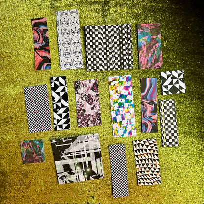 Collection of patterned sticker sheets on a textured green surface