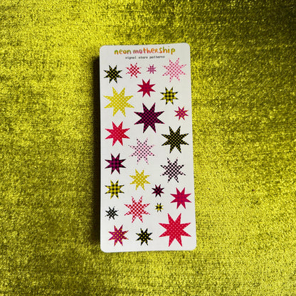 A rectangular sticker sheet from neon mother ship featuring various colorful embroidered star patterns, displayed on a textured yellow background.