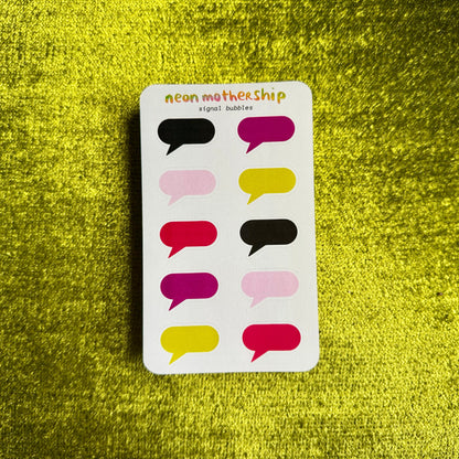 A white sticker sheet of neon mothership speech bubbles with 12 colorful sticker bubbles in shades of pink, yellow, red, and black, displayed on a textured yellow background.