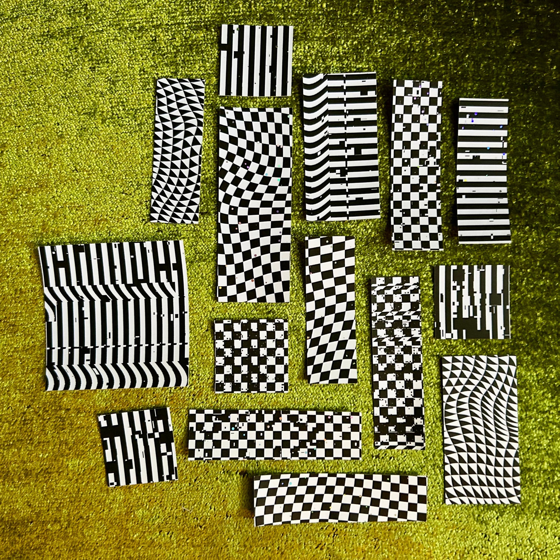 Black and white checkered stickers on a textured green surface