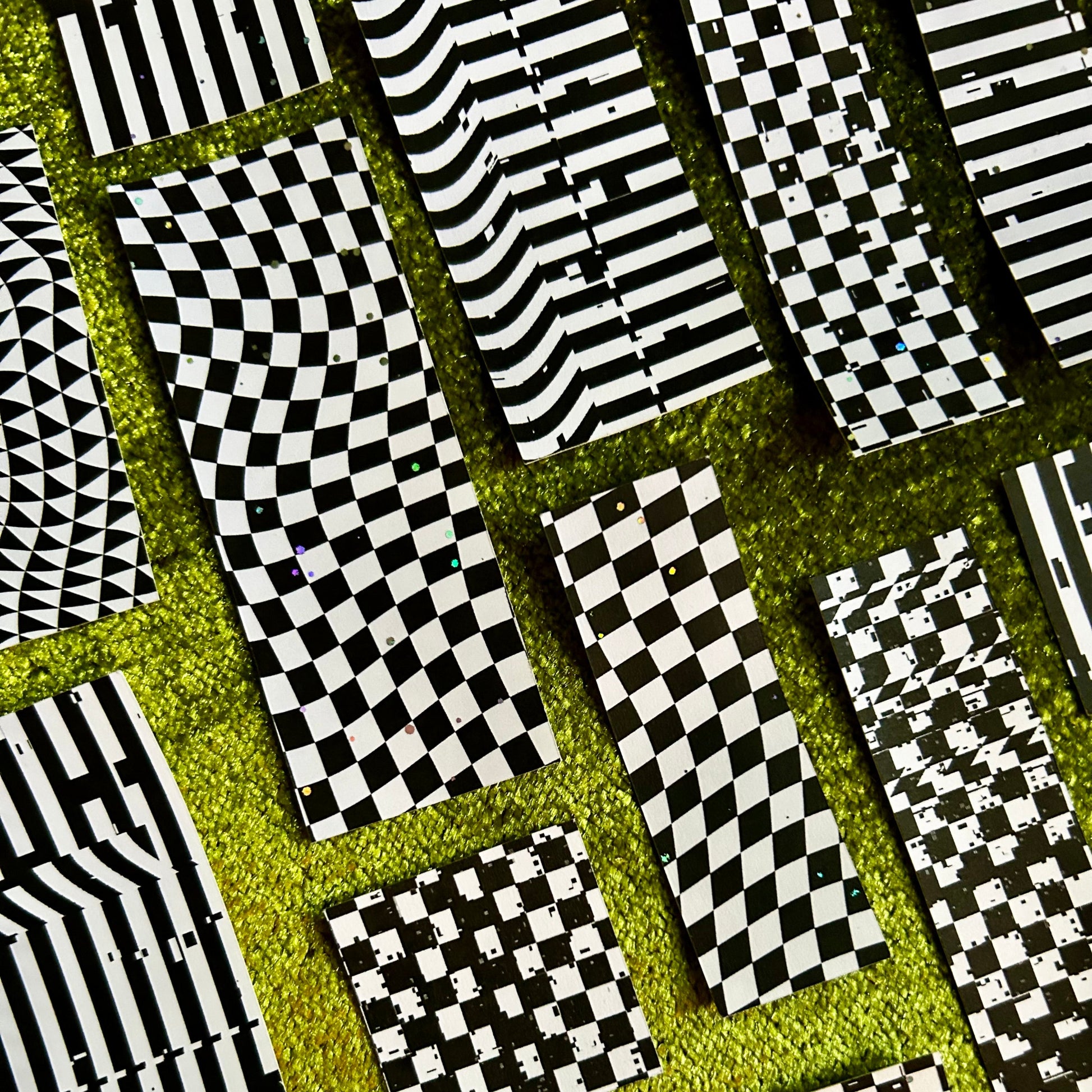 Patterned sticker scraps with black and white geometric designs on a green background