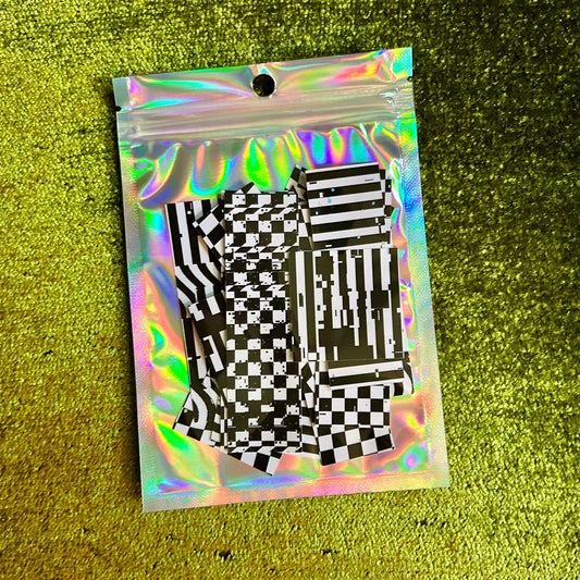 Holographic clear bag with black and white checkered stickers on a green textured background