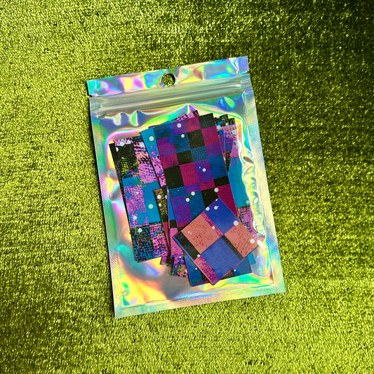 Holographic packaging with checkered patterned sticker scraps on a green textured background