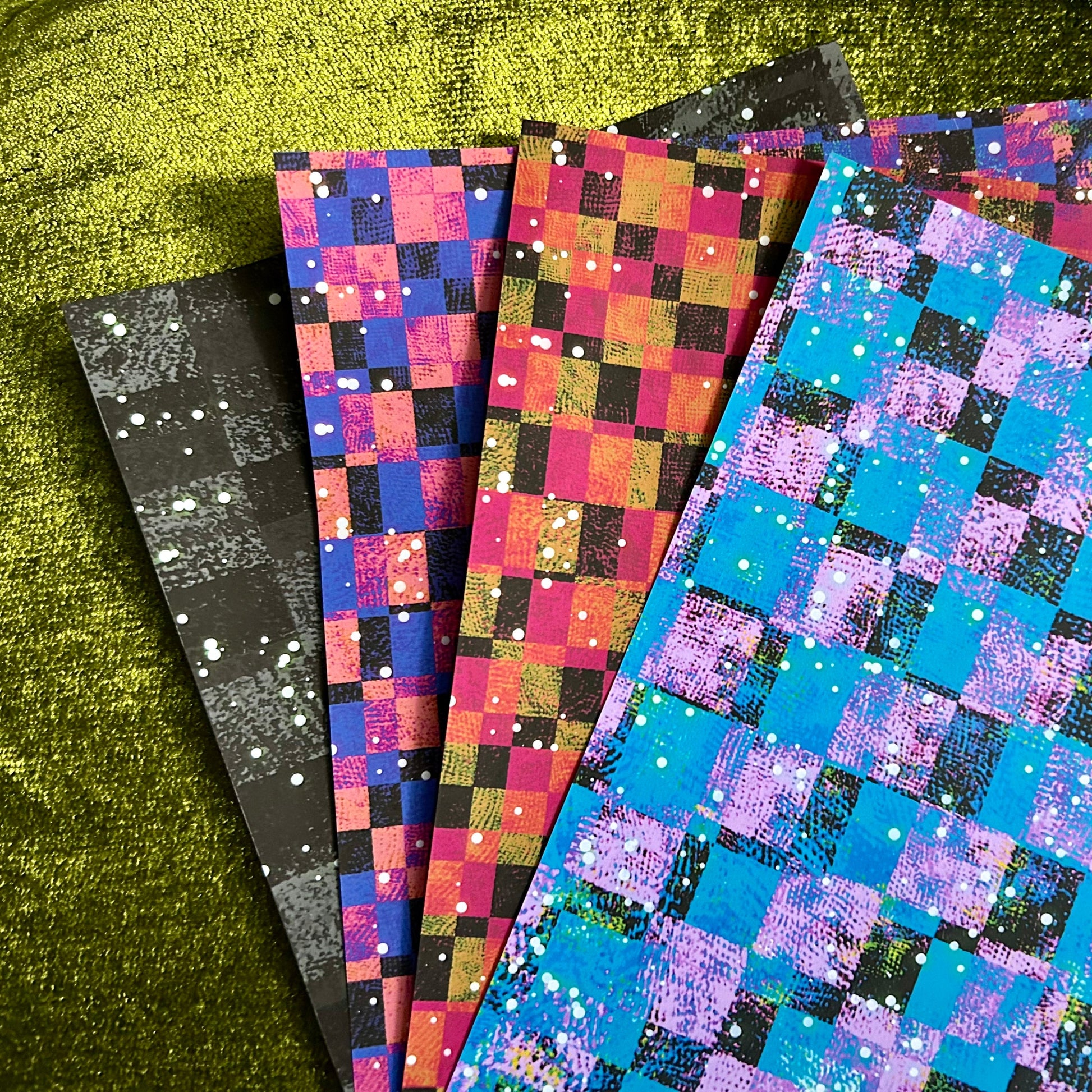 Set of colorful checkered paper sheets on a green surface