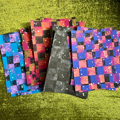 Set of colorful checkered papers on a green textured surface