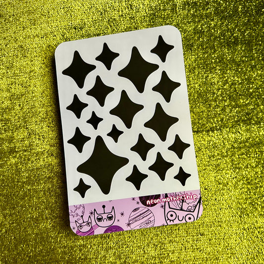 Sticker sheet with black star stickers on a green textured surface