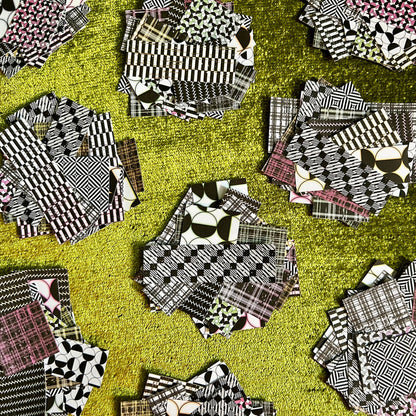 Collection of black and white patterned sticker scraps on a green background