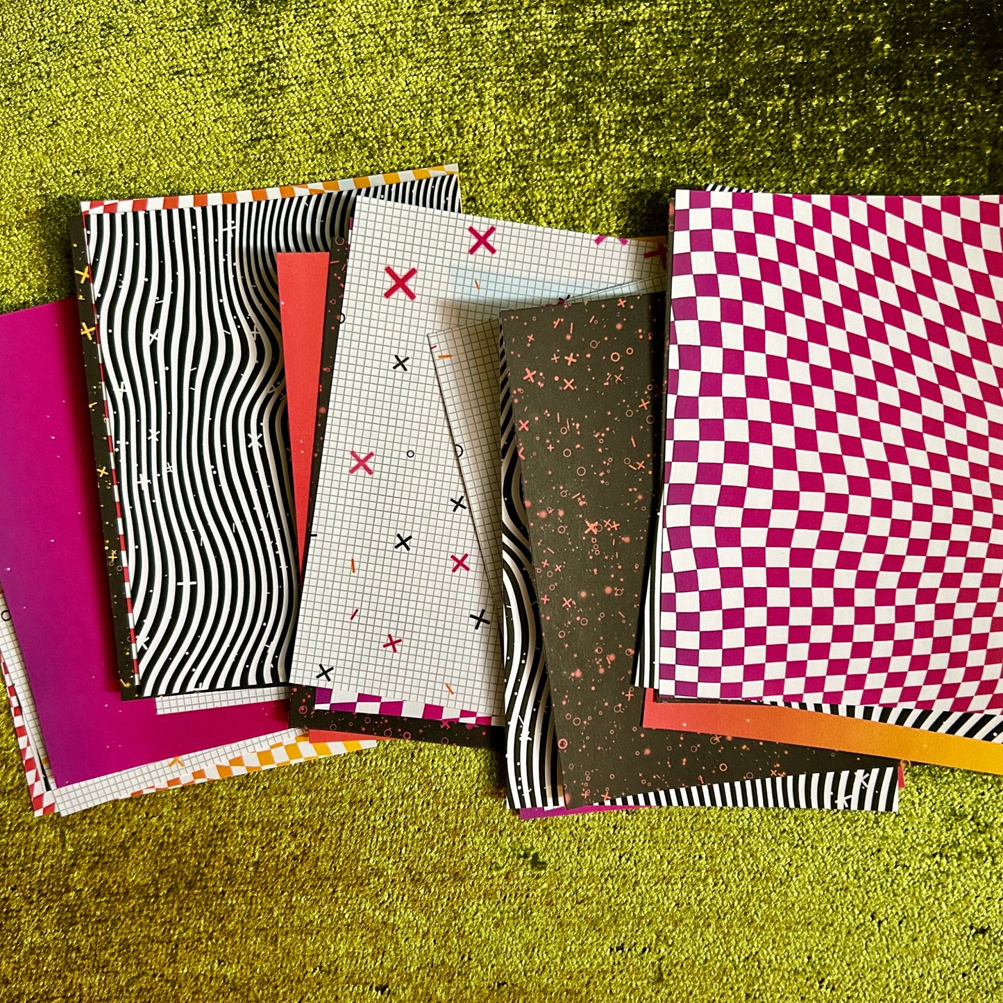 Collection of patterned pieces of sticker paper on a textured green surface