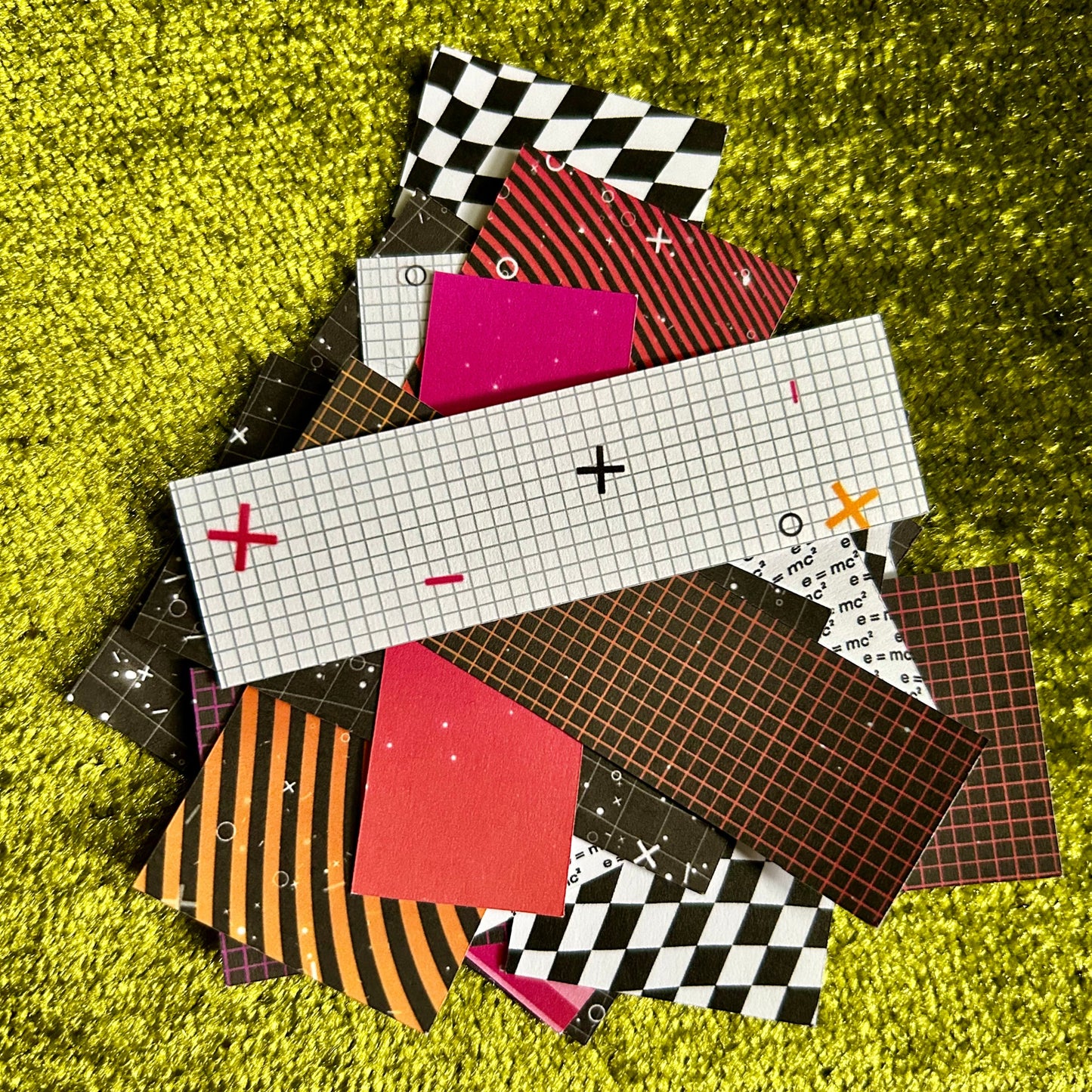 Collection of patterned paper squares on a green textured surface