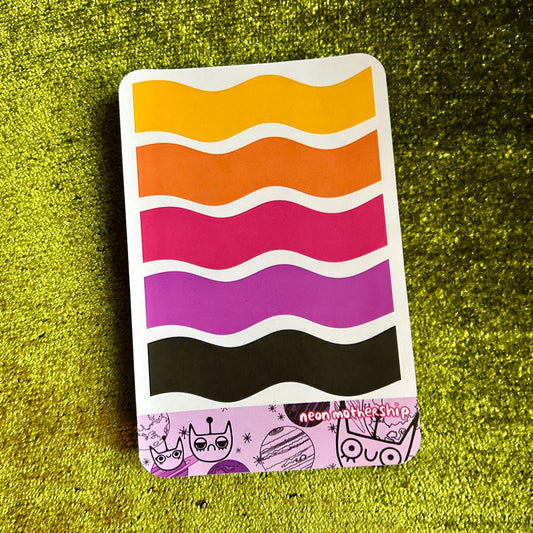 sticker sheet with wavy color pattern on a green textured surface