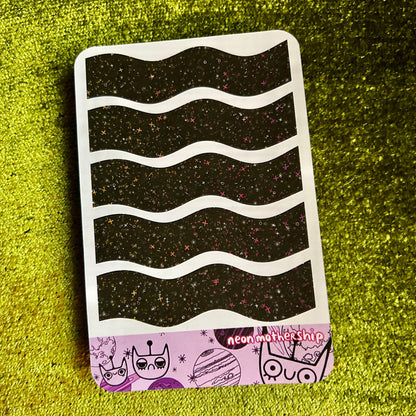 sticker sheet with wavy black pattern on a green textured surface