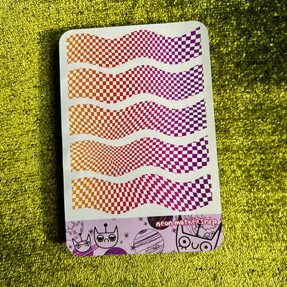 Sheet of colorful checkered and wavy pattern stickers on a green textured surface