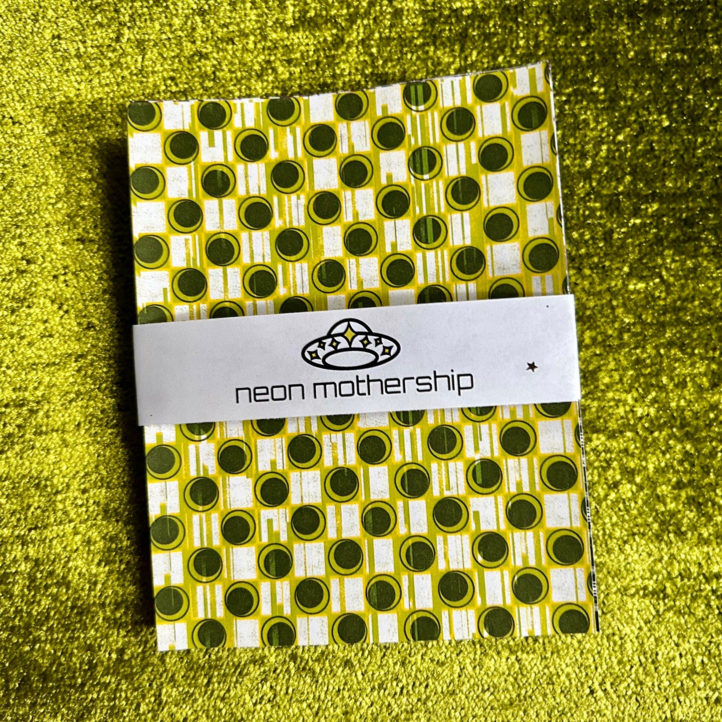 Packaged sticker sheets with a visible brand label on a green textured background