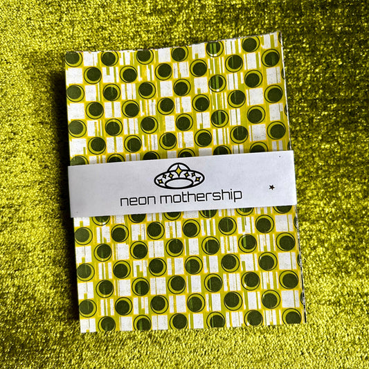 Packaged sticker sheets with a visible brand label on a green textured background