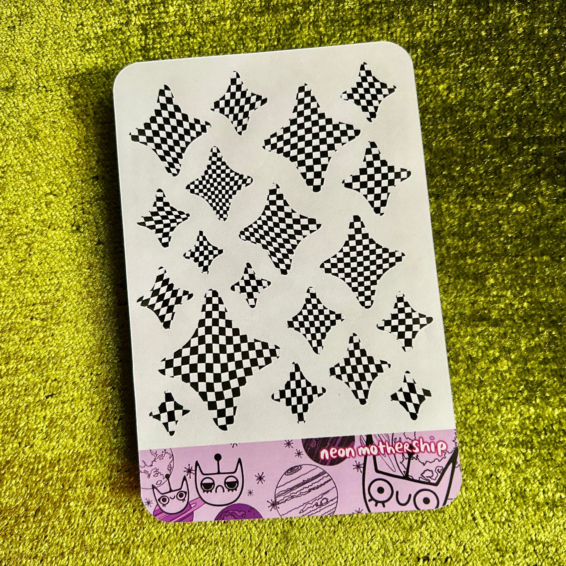 Sticker sheet with black and white pattern on a green textured surface