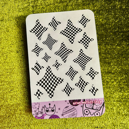 Sticker sheet with black and white pattern on a green textured surface