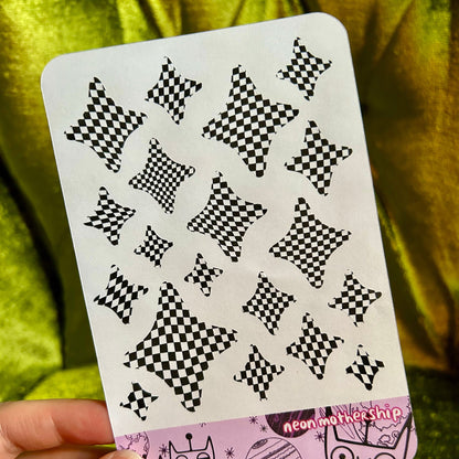 sticker sheet with black star patterns on a green fabric background