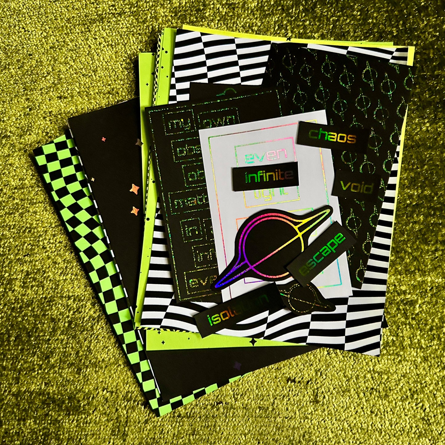 Stack of papers with various designs on a textured green surface