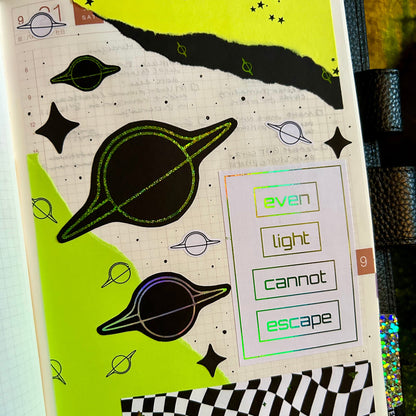 Notebook cover with space-themed design, planets, and text on a green background