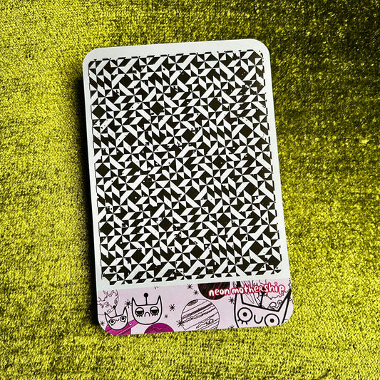 Black and white patterned sticker sheet with cartoon characters on a green textured surface