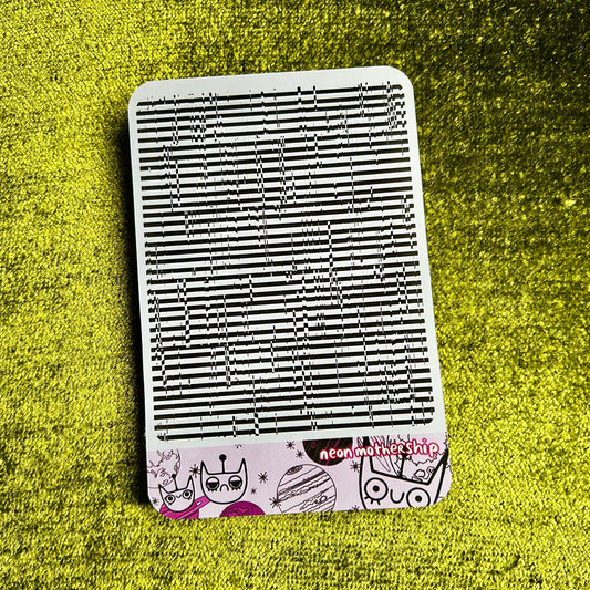 sticker sheet with black and white design on a green textured surface