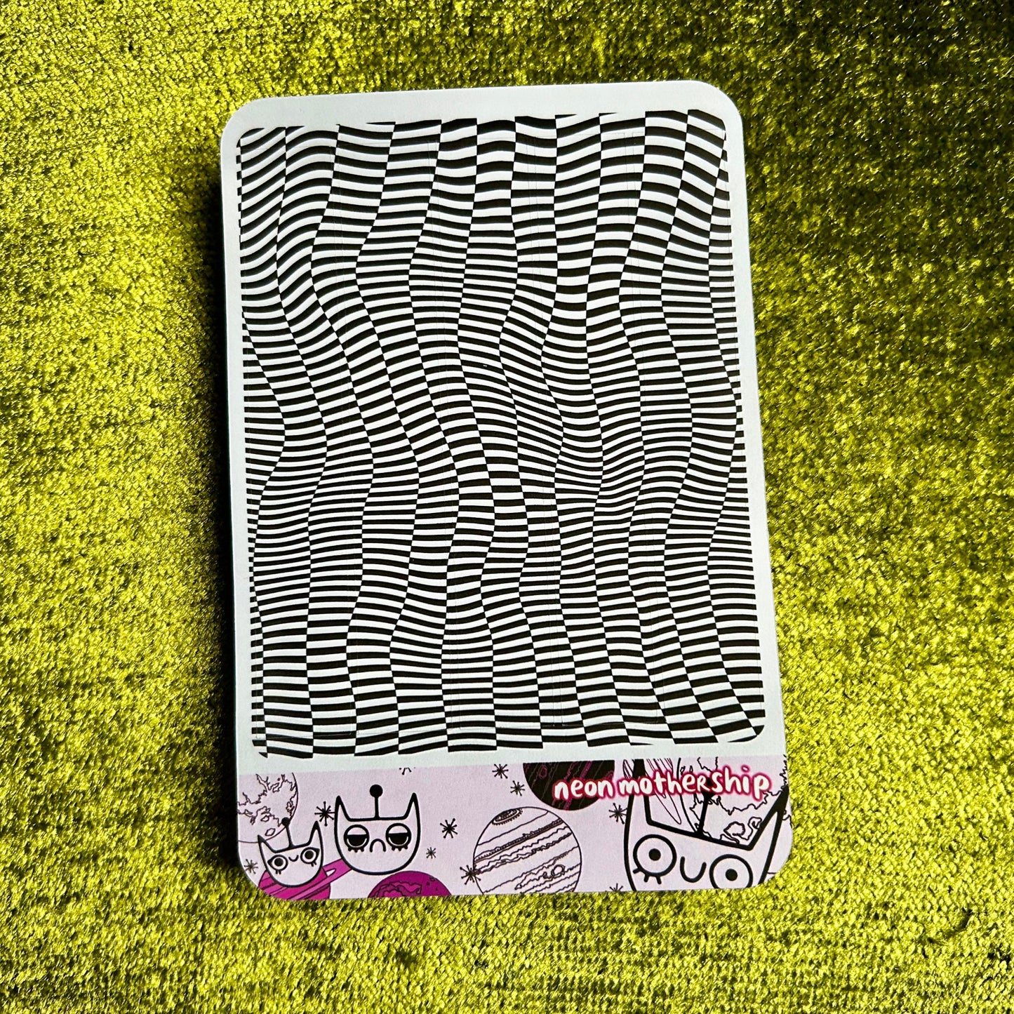 sticker sheet with black and white wavy pattern on a green textured surface
