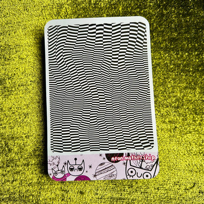 sticker sheet with black and white wavy pattern on a green textured surface