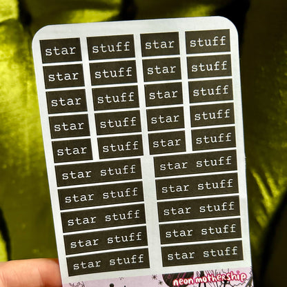 Sheet of 'star stuff' stickers held by a hand with a green background
