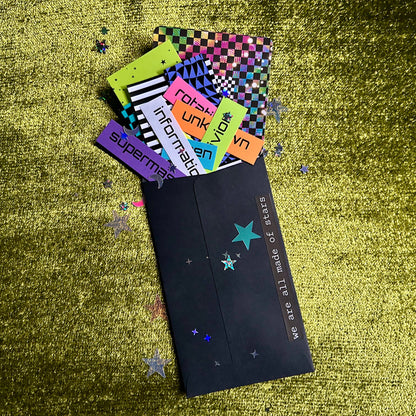 Colorful papers with various designs and text on a textured green surface.