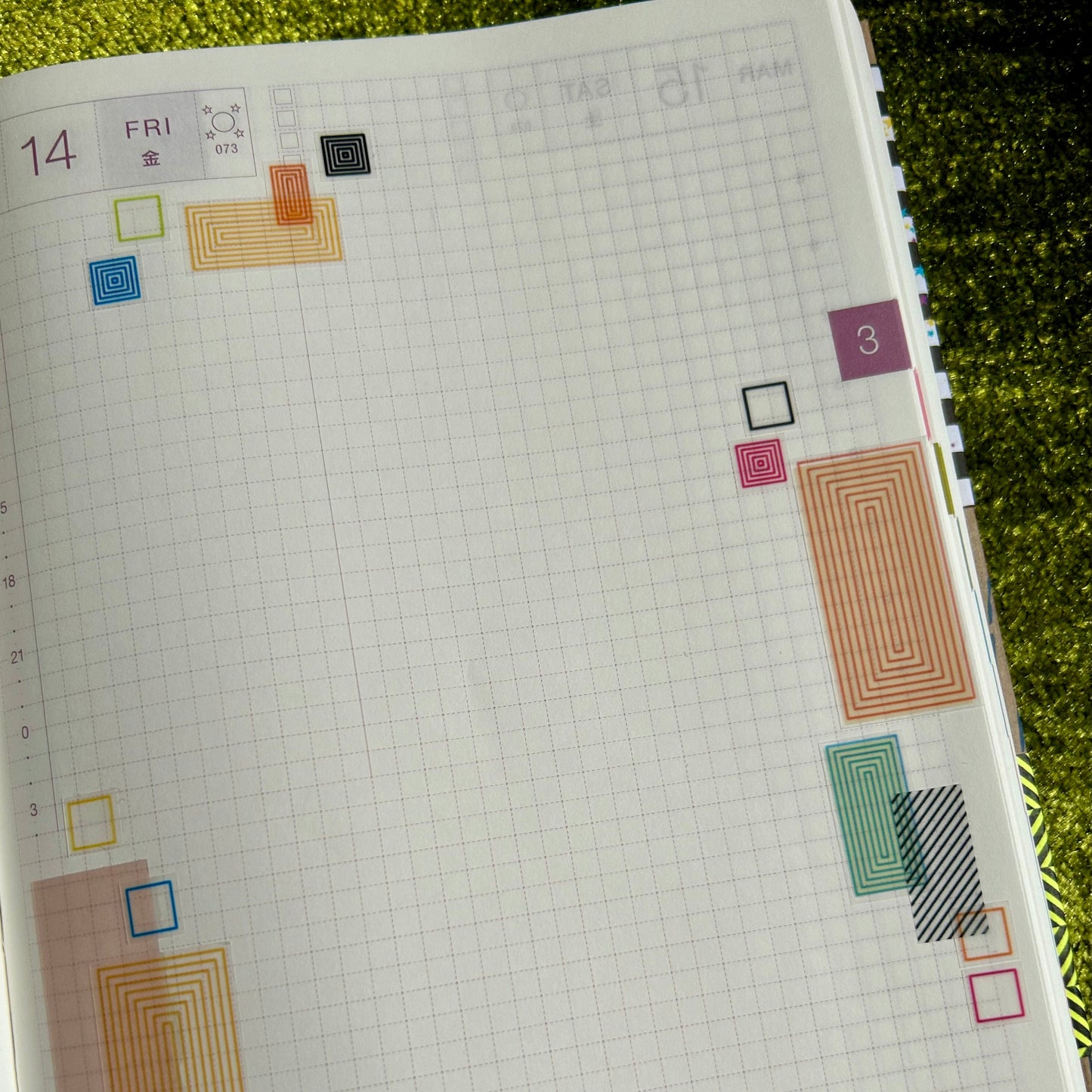 Planner page with colorful geometric shapes on a green surface