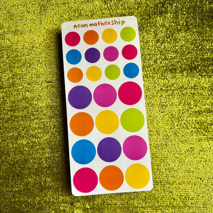 Colorful dot stickers on a green textured background