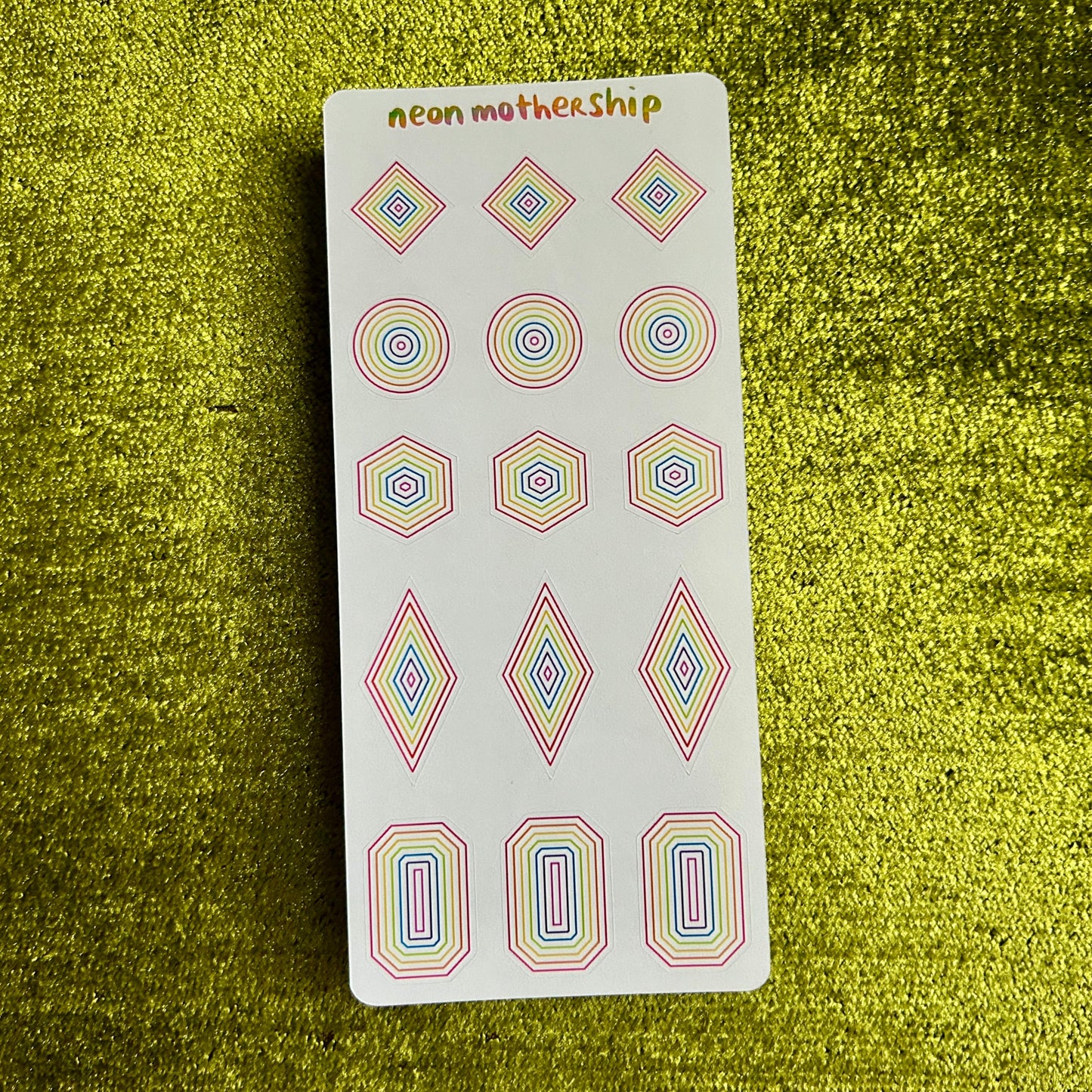 sticker sheet with geometric stickers on a green textured background