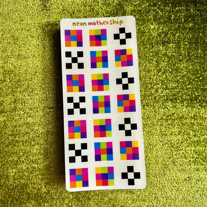 Sticker with colorful geometric patterns on a green textured surface